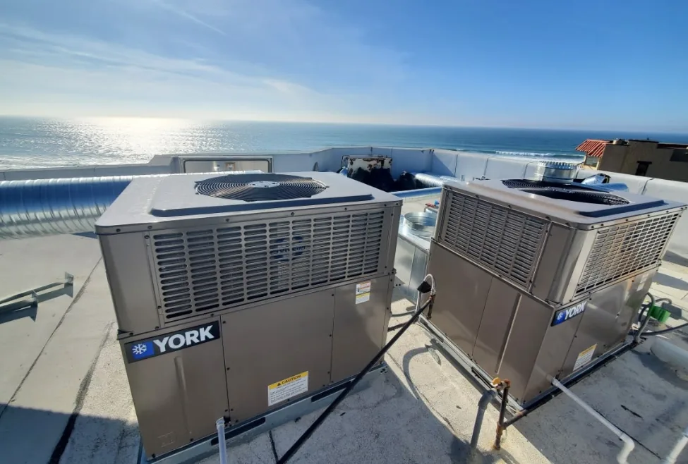 Two rooftop HVAC units overlooking the ocean in San Diego, symbolizing air conditioner breakdown concerns; relevant for